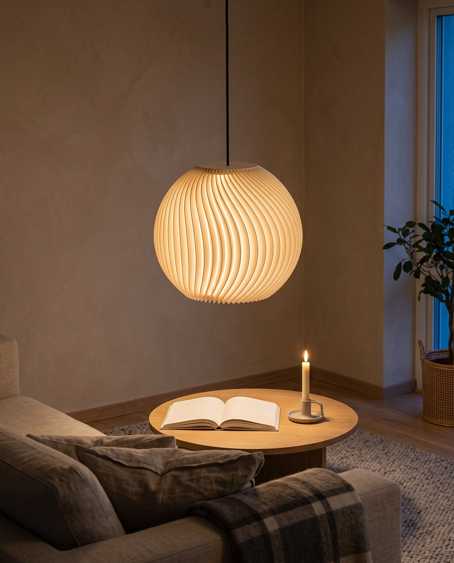 Onda Kugel-Lampenschirm in Beige, eingeschaltet über dem Couchtisch im Wohnzimmer mit Sofa und Kerze