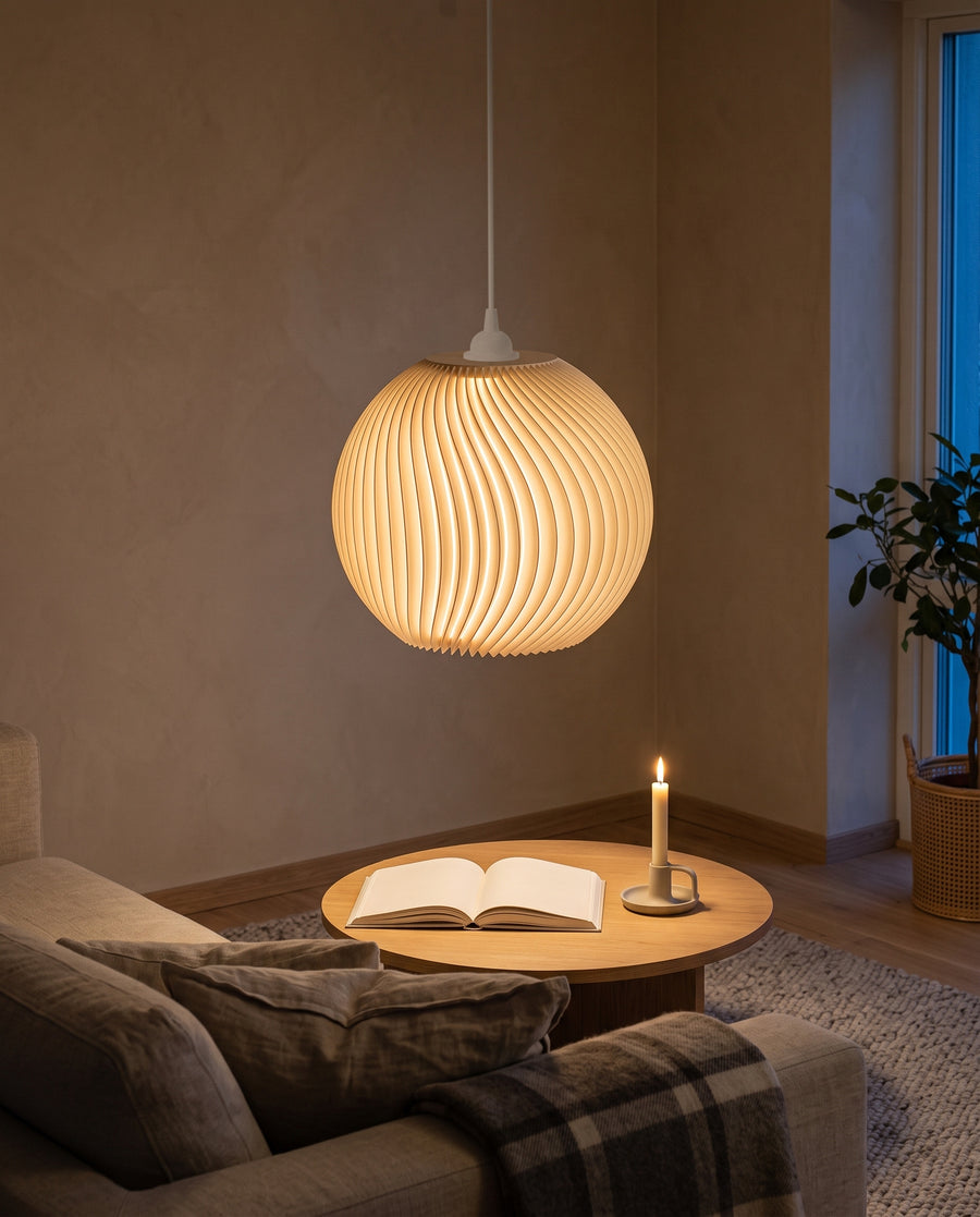 Onda Lampenschirm in Beige als Kugellampe über dem Couchtisch im Wohnzimmer, eingeschaltet mit Sofa und Kerze