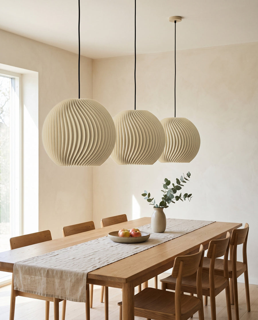 Drei Onda Kugel-Lampenschirme in Beige in einer Reihe über dem langen Esstisch, ausgeschaltet