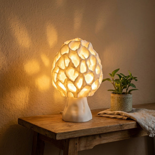 Pilzlampe weiß – Morchel mit Wabenstruktur leuchtet warm auf einem Holztisch