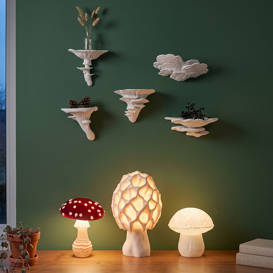 Fünf weiße Pilz-Wandregale an waldgrüner Wand im kühlen Dämmerlicht, ohne Lampen, über einem Holz-Sideboard.