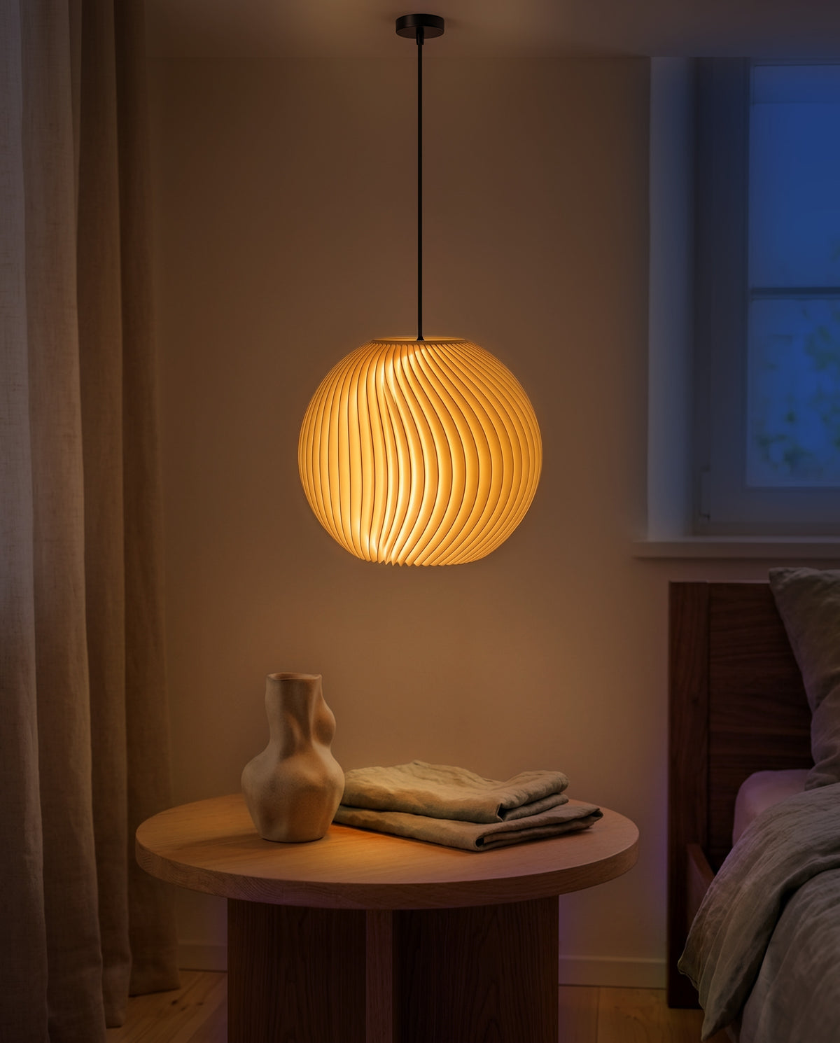 Onda Lampenschirm Kugel in Gelb als Pendelleuchte im Schlafzimmer, am Abend gedimmt eingeschaltet